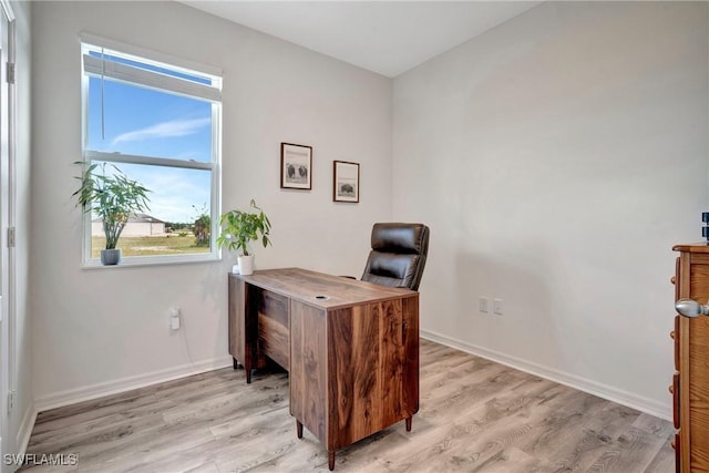 home office with light wood-type flooring and baseboards