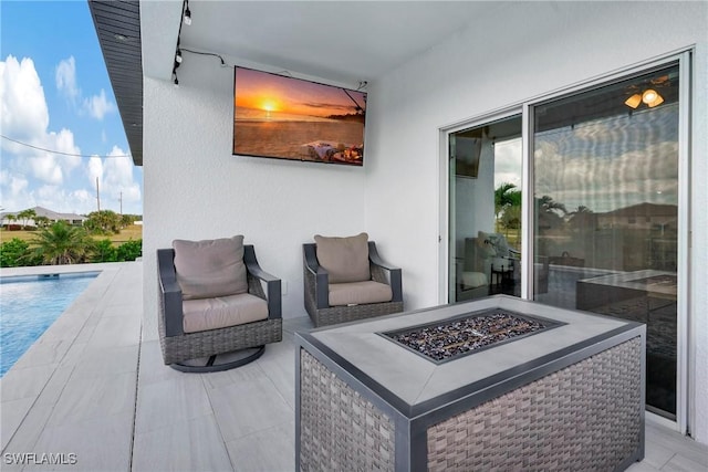 view of patio featuring an outdoor pool and a fire pit