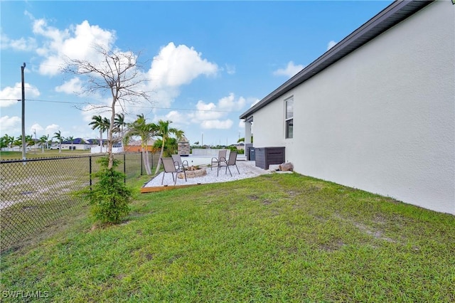 view of yard featuring a patio area, fence, and central air condition unit