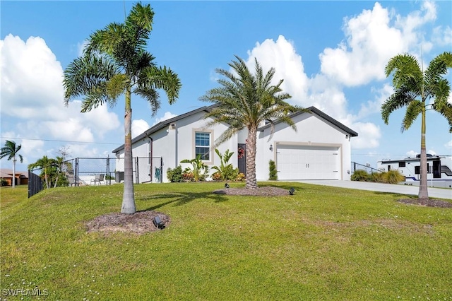 view of front of home with stucco siding, concrete driveway, a front yard, fence, and a garage