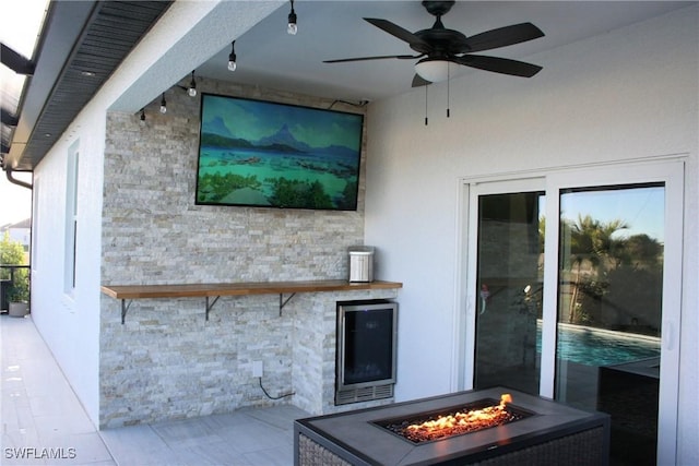 view of patio featuring an outdoor fire pit and a ceiling fan