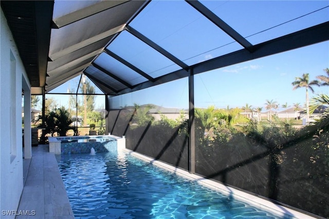 view of pool with glass enclosure and a pool with connected hot tub