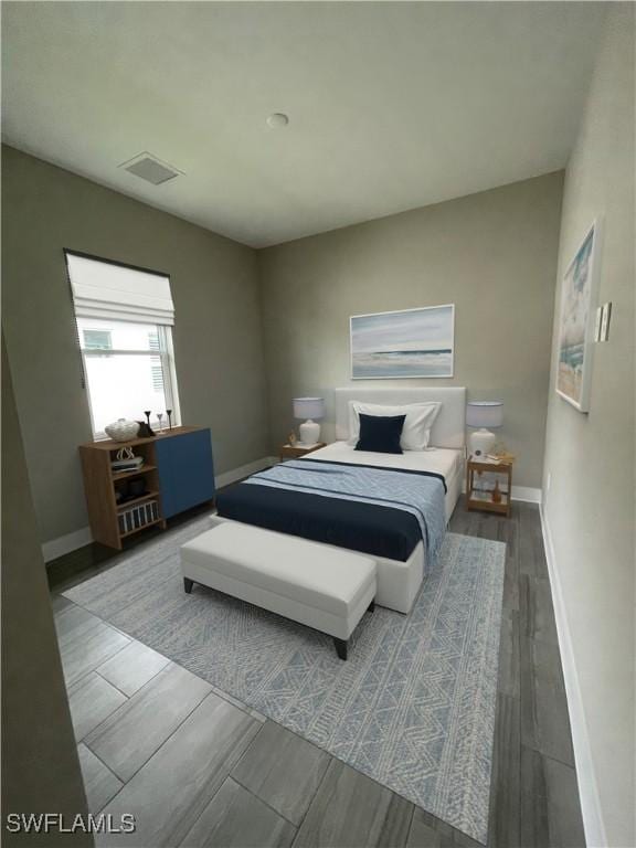 bedroom featuring wood finish floors, visible vents, and baseboards