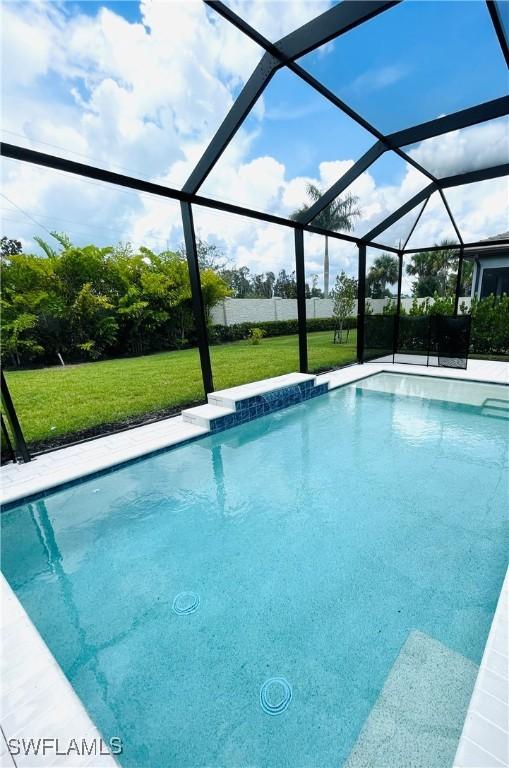 pool with glass enclosure and a yard