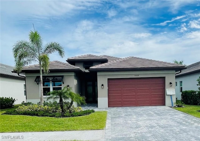 view of front facade with a garage, a tile roof, decorative driveway, and stucco siding