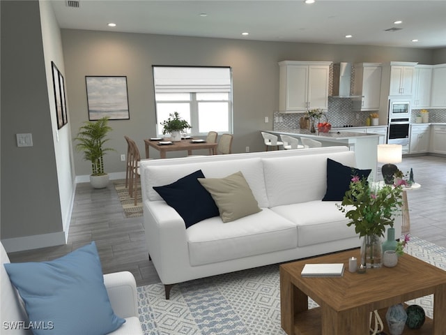 living room with baseboards, visible vents, and recessed lighting