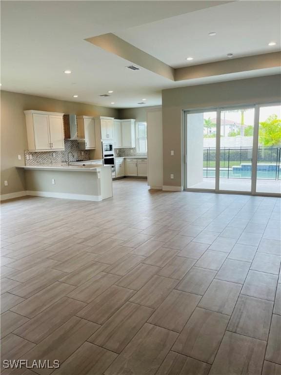 3608 Sapphire Cove Cir, Naples, FL 34114 - kitchen featuring tasteful backsplash, open floor plan, light countertops, and a peninsula