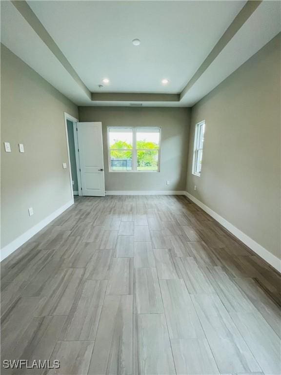 spare room featuring recessed lighting and baseboards