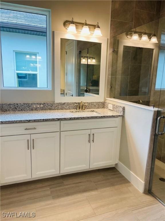 bathroom with a shower stall and vanity