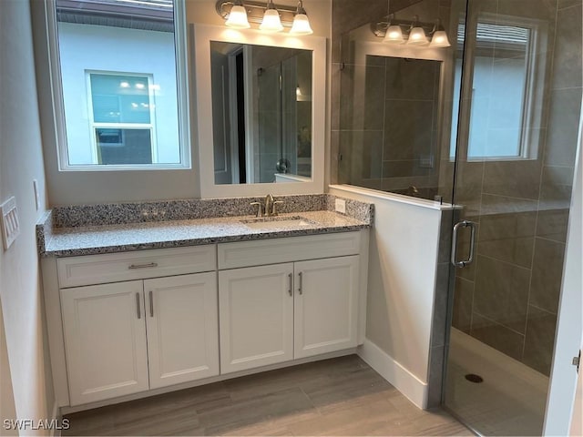 bathroom with a shower stall and vanity