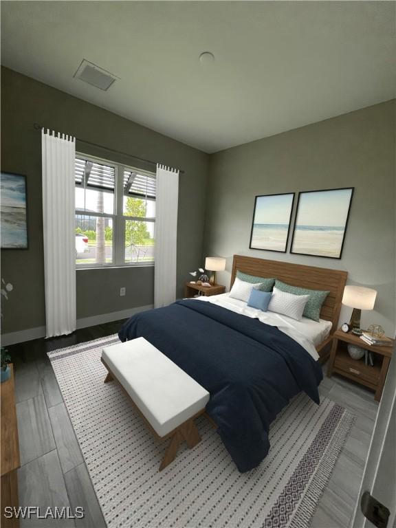 bedroom featuring visible vents, baseboards, and wood finished floors