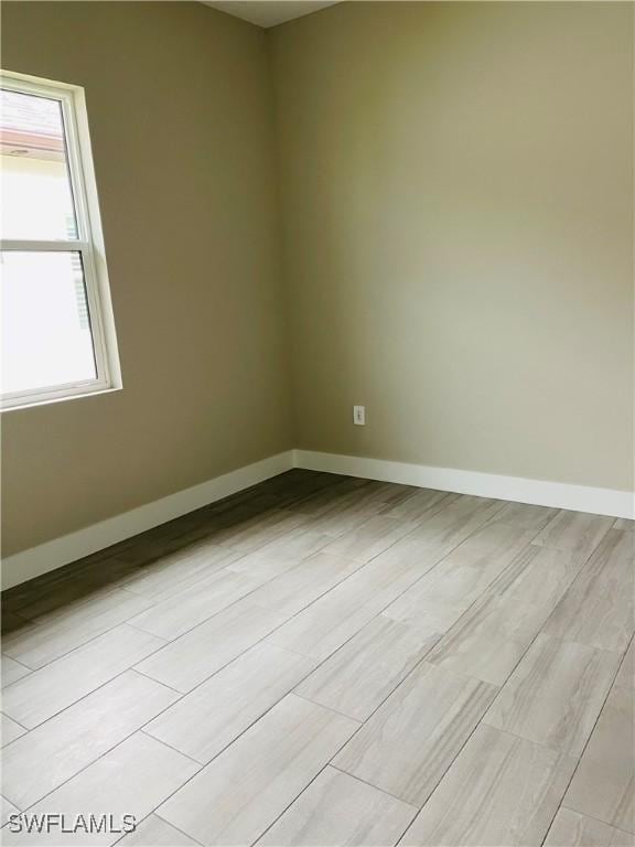 unfurnished room featuring light wood-type flooring and baseboards