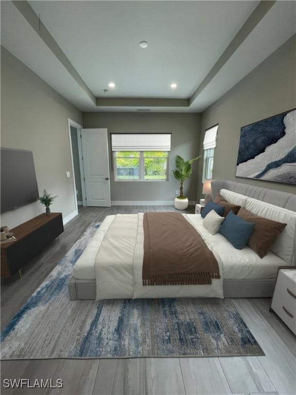 3608 Sapphire Cove Cir, Naples, FL 34114 - bedroom with wood finished floors, recessed lighting, a tray ceiling, and baseboards