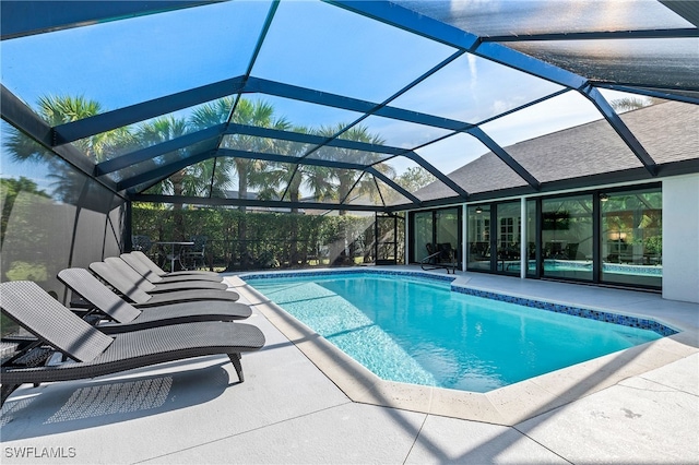 outdoor pool with a lanai and a patio area