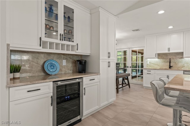 bar featuring wine cooler, french doors, tasteful backsplash, visible vents, and a bar