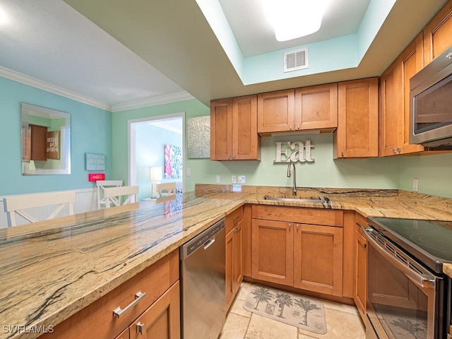 kitchen with visible vents, appliances with stainless steel finishes, light stone counters, and a sink