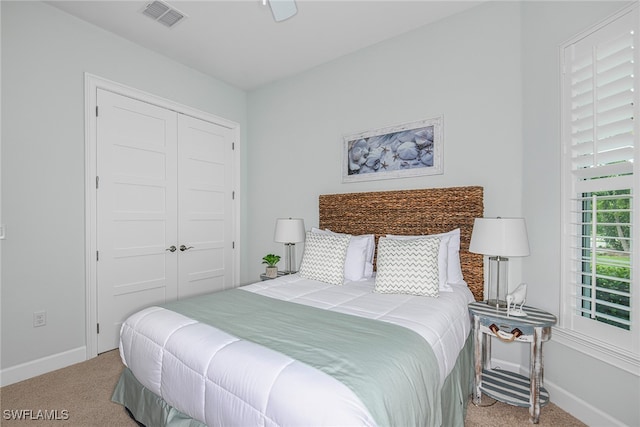 bedroom featuring baseboards, visible vents, a closet, and light colored carpet