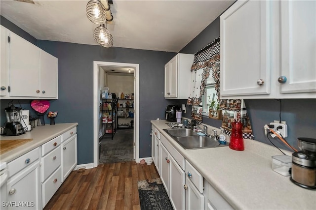 kitchen with dark wood-style flooring, white cabinets, a sink, and light countertops