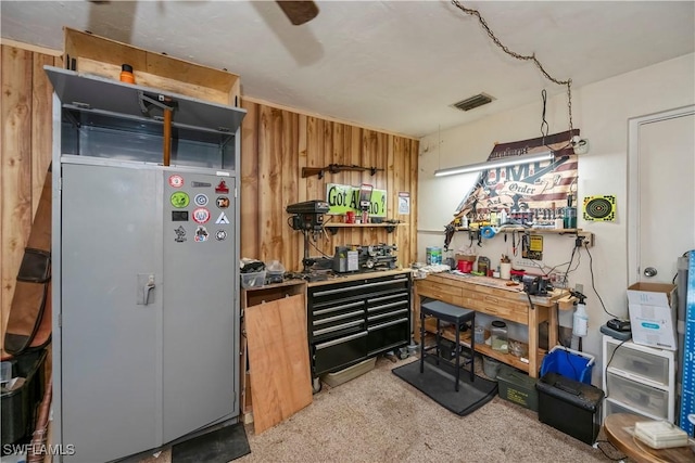 kitchen featuring ceiling fan, visible vents, and wooden walls