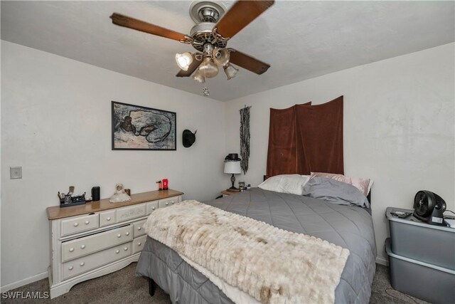 bedroom featuring baseboards, dark carpet, and a ceiling fan