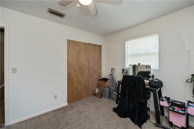 carpeted office with a ceiling fan, visible vents, and baseboards