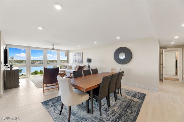 dining area with baseboards, visible vents, a wall of windows, light wood-style floors, and recessed lighting