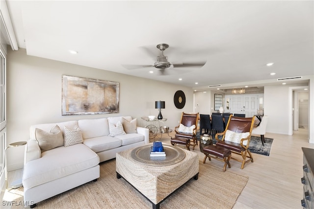 living room featuring light wood-style floors, a ceiling fan, and recessed lighting