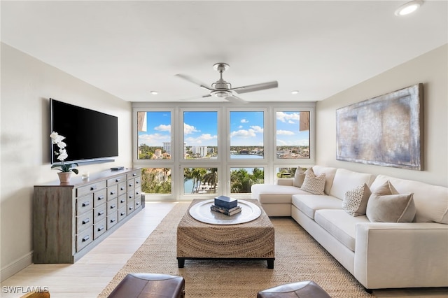 living area with ceiling fan, recessed lighting, light wood-type flooring, and baseboards