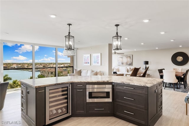 kitchen with light wood-style floors, wine cooler, and open floor plan