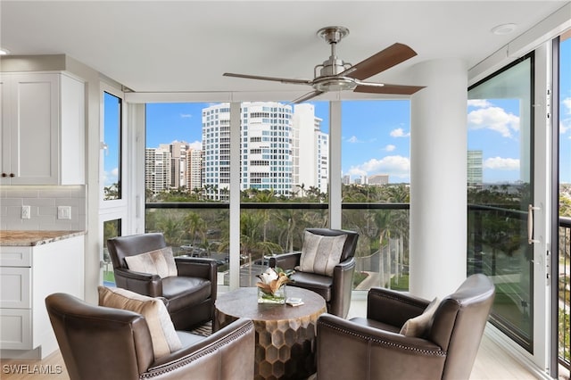 sunroom with a city view and ceiling fan