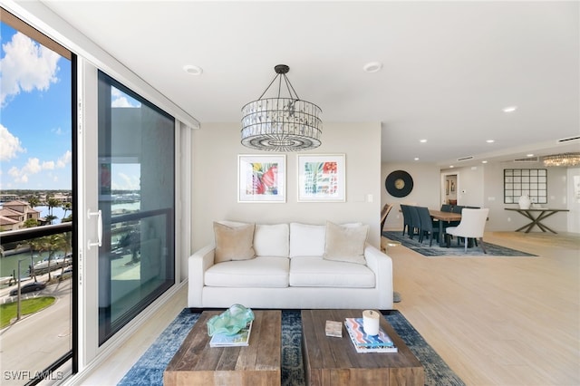 living area with a notable chandelier, recessed lighting, wood finished floors, and floor to ceiling windows