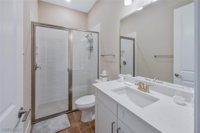 full bathroom with toilet, a stall shower, wood finished floors, and vanity