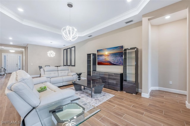 living room with visible vents, a raised ceiling, wood tiled floor, crown molding, and a chandelier