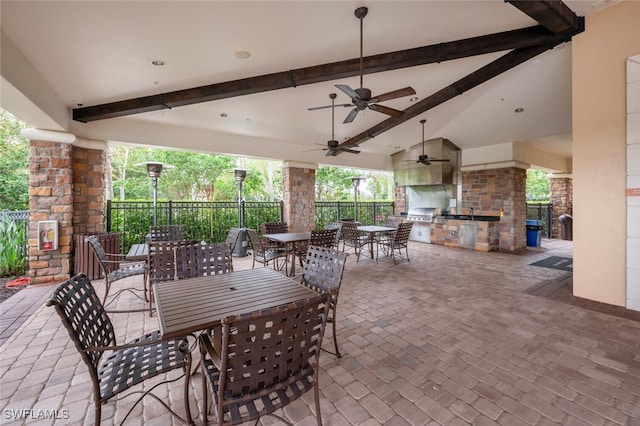 view of patio / terrace featuring an outdoor kitchen, fence, a ceiling fan, grilling area, and outdoor dining space