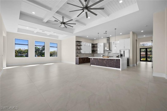 unfurnished living room with beamed ceiling, recessed lighting, baseboards, and coffered ceiling