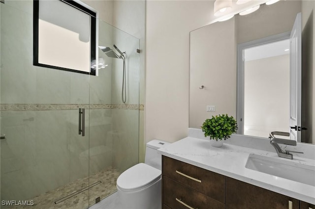 bathroom with vanity, toilet, and a shower stall