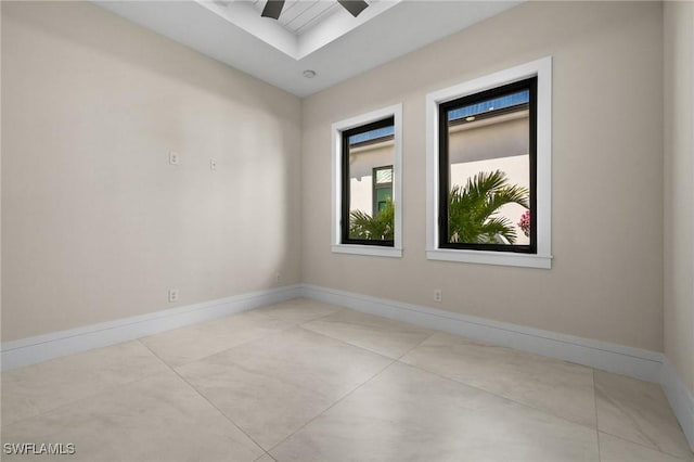 unfurnished room with a ceiling fan and baseboards