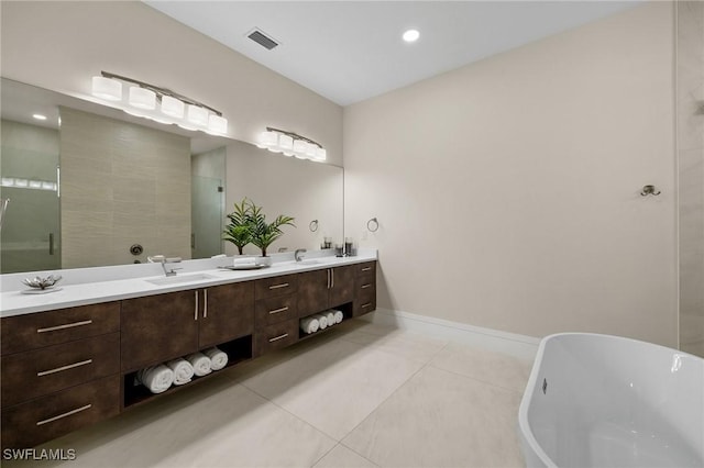 full bathroom featuring tile patterned floors, visible vents, a sink, double vanity, and a freestanding bath