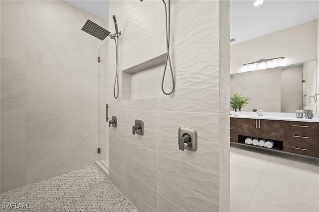 bathroom featuring tile patterned floors, tiled shower, and vanity