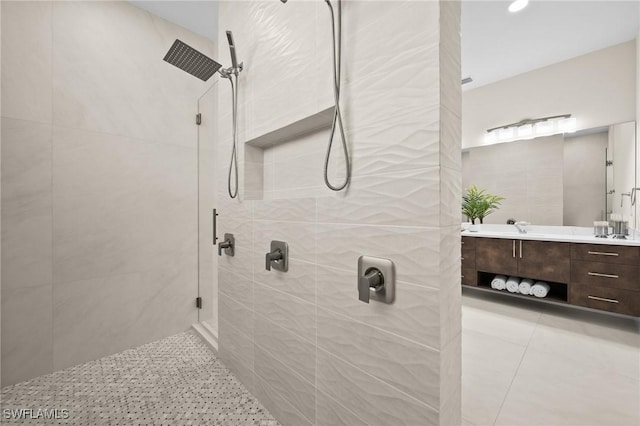 bathroom featuring vanity, tile patterned flooring, and tiled shower