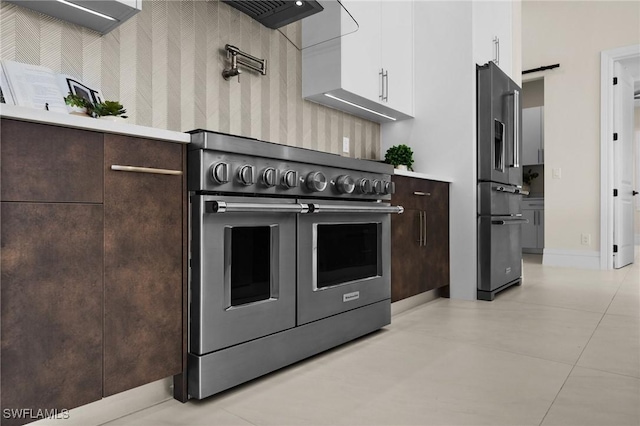 kitchen with dark brown cabinets, white cabinetry, high end appliances, and light countertops