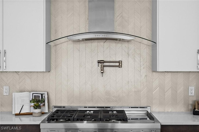 room details with decorative backsplash, light countertops, wall chimney exhaust hood, and range