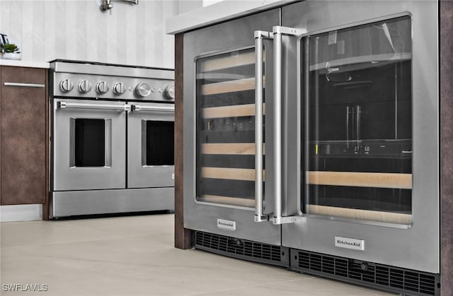 kitchen featuring range with two ovens, dark brown cabinets, and beverage cooler