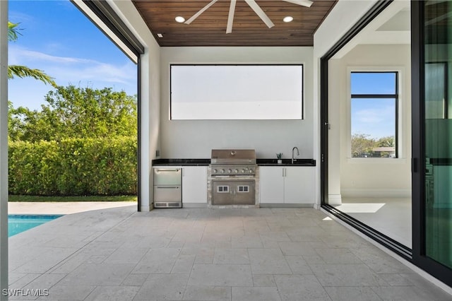 view of patio / terrace featuring a sink, an outdoor kitchen, grilling area, an outdoor pool, and ceiling fan