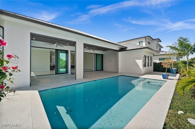 back of property with ceiling fan, stucco siding, metal roof, a patio area, and a standing seam roof