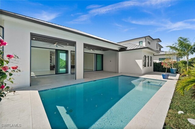 view of swimming pool featuring ceiling fan, a pool with connected hot tub, and a patio