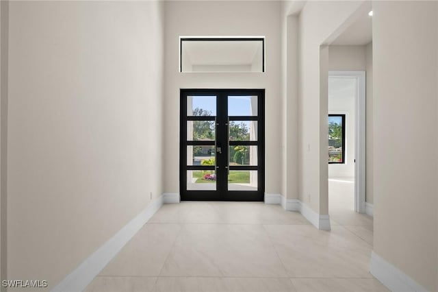 tiled entryway with french doors and baseboards