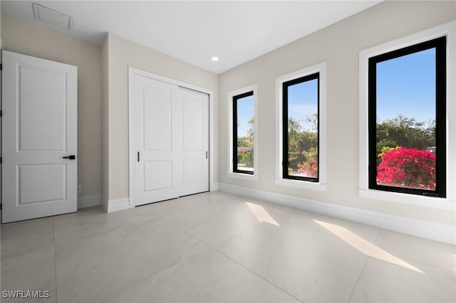 unfurnished bedroom featuring recessed lighting, a closet, and baseboards