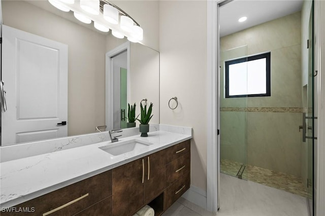 bathroom with baseboards, a stall shower, and vanity