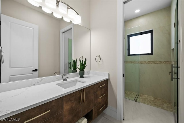 bathroom featuring baseboards, vanity, and a shower stall